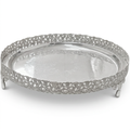 A round silver serving tray with an ornate filigree raised rim and small feet, shown on a clean white background.