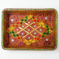 A rectangular decorative tray with a colorful embroidered pattern, featuring a central diamond motif in yellow, green, and red with gold metallic accents and small silver mirror embellishments, set against a plain white background.